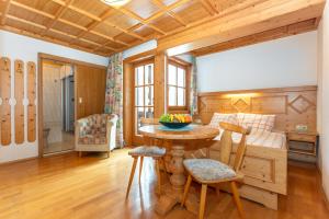 a kitchen with a table and chairs in a room at lechner living apartments in Wald im Pinzgau