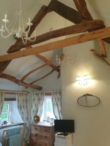 a room with a ceiling with wooden beams at The Old Mill Cottage in Okehampton
