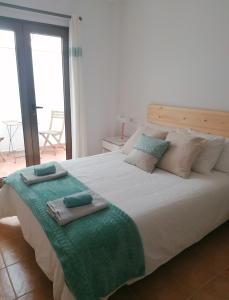 a bedroom with a large bed with two towels on it at Casa Calderetas in San Bartolomé