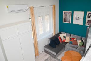 - un salon avec un canapé gris et des oreillers colorés dans l'établissement Petőfi Apartman Pécs, à Pécs