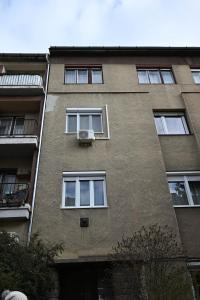 - un grand bâtiment en briques avec des fenêtres et un balcon dans l'établissement Petőfi Apartman Pécs, à Pécs