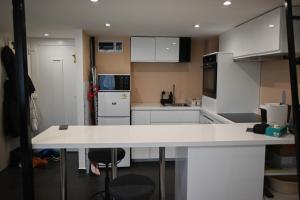 a kitchen with white cabinets and a white counter top at Petőfi Apartman Pécs in Pécs