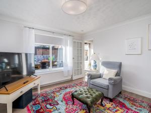 een woonkamer met een stoel en een televisie bij Pass the Keys Stylish Cosy 3Bed Family Friendly Home in Hatfield in Hatfield