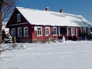 una casa roja con nieve encima en Aimasas, en Soleimi