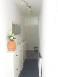 a white bathroom with a sink and a mirror at Cosy studio flat, great location! in London