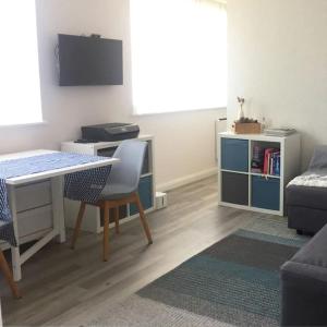 a living room with a table and a chair and a desk at Cosy studio flat, great location! in London
