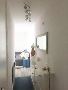 a white room with a bed and a mirror at Cosy studio flat, great location! in London
