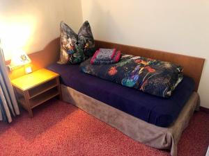 Cama en habitación con mesa auxiliar y lámpara en Hotel Eulenspiegel - Das Erlebnishotel in Riesa, en Riesa