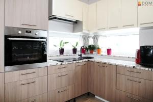 a kitchen with wooden cabinets and a stove top oven at Veski Villa in Pärnu +14 photos