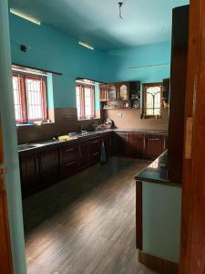 a large kitchen with wooden floors and blue walls at PAARK in Nāgercoil
