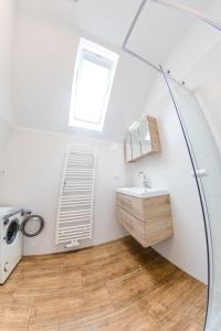 ein Bad mit einem Waschbecken und einem Fenster in der Unterkunft Weingut Guttmann - Apartment Schwalbennester in Weiden am See