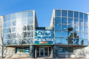 un immeuble de bureaux avec un panneau devant lui dans l'établissement Résidence Otellia, à Blanquefort