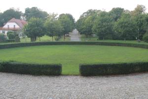 a large green park with hedges in the middle at Schloss Alt Sammit in Krakow am See