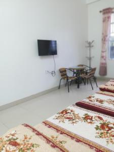 Habitación con 2 alfombras, mesa y TV. en Nhà nghỉ Hà Giang, en Lạng Sơn