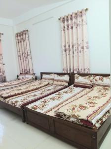 2 camas en una habitación con cortinas en Nhà nghỉ Hà Giang, en Lạng Sơn