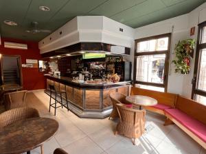 un restaurante con un bar con mesas y sillas en Hostal Tarrés, en Anglés
