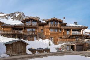 a large wooden house with snow in front of it at Chalet Opale in Tignes