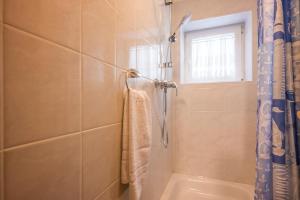 a bathroom with a shower and a tub and a window at Gemütliche Ferienwohnung für Singles, FeWo 9 in Thiersee