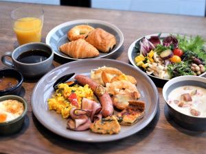 a table topped with plates of breakfast foods and drinks at the square hotel KANAZAWA in Kanazawa