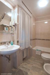 希洪的住宿－卡斯蒂利亞酒店，浴室配有盥洗盆、卫生间和浴缸。