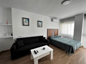 salon z kanapą i łóżkiem w obiekcie VER7 - ESTUDIO, Wifi, Fire Stick Amazon, Terraza, Vistas al mar, Piscina w mieście Torremolinos