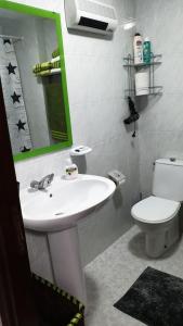 ein Badezimmer mit Waschbecken, Toilette und Spiegel in der Unterkunft Piso vistas al mar. Playa de Aguete. Rías Baixas. in Marín + 7 Fotos