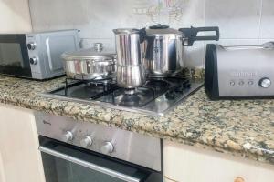 einen Herd mit Töpfen und Pfannen darüber in der Unterkunft Piso vistas al mar. Playa de Aguete. Rías Baixas. in Marín