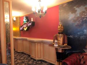 Hotel Eulenspiegel - Das Erlebnishotel in Riesa في ريزا: تمثال رجل جالس في بار في مطعم