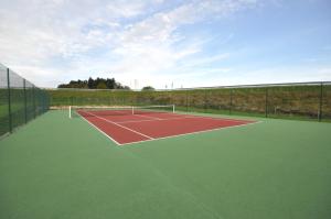 a tennis court with a net on top of it at The Originals City, Hôtel Alexia, La Souterraine (Inter-Hotel) in La Souterraine