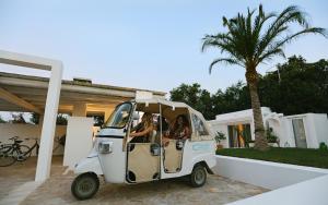 dos personas en un pequeño vehículo estacionado frente a una casa en Dimora Santa Caterina en Polignano a Mare