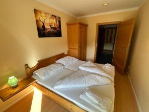 a bedroom with a bed with white sheets at Moderne Ferienwohnung im Familienparadies MoNi, FeWo 12 in Thiersee