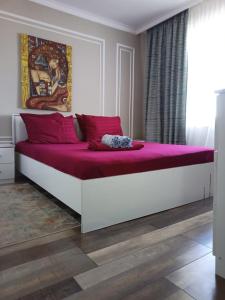 a large bed with pink sheets in a bedroom at Avtovokzal 3 Room apt in Qyzylorda