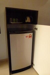 - un petit réfrigérateur dans une cuisine avec une étagère au-dessus dans l'établissement Cheers Garden Chalet, à Kampung Tekek