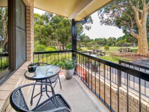 a balcony with a table and chairs and a view of a park at Kandos Fairways Motel in Kandos