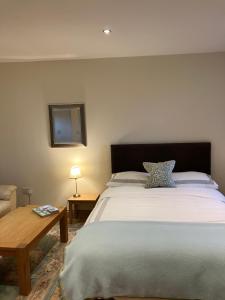 a bedroom with a large bed and a table at The Courtyard in Errol