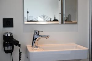 a bathroom sink with a hair dryer next to a mirror at Roatel Möckern A2 my-roatel-com 