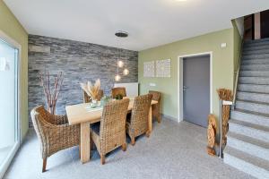 a dining room with a table and wicker chairs at Luxus Apartments Mosel-Zeit NEU 2023 in Zell an der Mosel