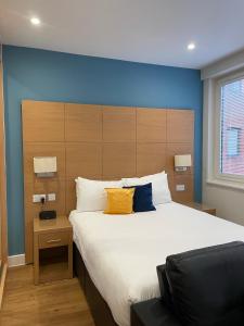 a bedroom with a large bed with a blue wall at House of Fisher - 100 Kings Road in Reading