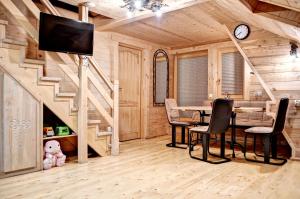 a dining room with a table and a tv in a log cabin at Apartamenty Światłomir in Zakopane