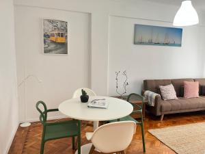 uma sala de estar com uma mesa e cadeiras e um sofá em 92 Campolide Apartment by Trip2Portugal em Lisboa