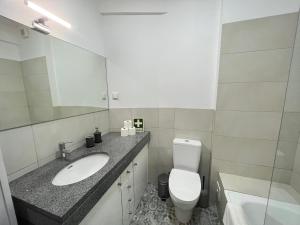 W łazience znajduje się umywalka, toaleta i lustro. w obiekcie 92 Campolide Apartment by Trip2Portugal w Lizbonie