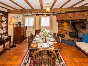 a dining room with a table and a fireplace at Pass the Keys Malt House With Hot Tub Stunning Tudor Cottage in Craven Arms
