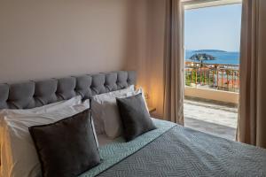 une chambre avec un lit avec vue sur l'océan dans l'établissement Iliana Apartments, à Tolón