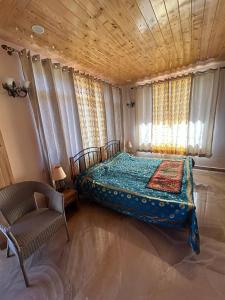 um quarto com uma cama e uma cadeira em Idyllic Private Cottage w/King Bed + Mountain view em Kasauli