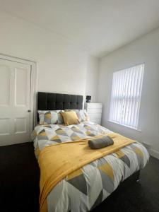 a bedroom with a bed with a blanket on it at Large 3 bed - 10 mins to centre in Liverpool