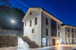 un gran edificio blanco con escaleras junto a una pista de tenis en Apartamentos Buenavista Tineo en Tineo