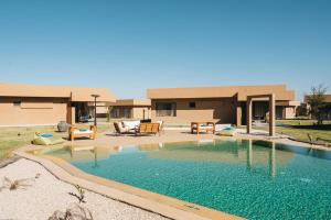 a swimming pool in front of a building at Tulum Beach Resort Dakhla in Dakhla