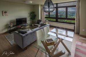 a living room with a couch and a table at Apartamentos Buenavista Tineo in Tineo