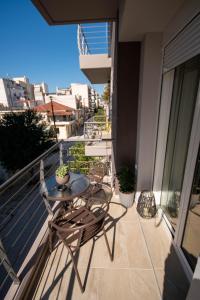 balcone con tavolo e sedie. di Kate's Luxury Apartment with Private Parking a Volos