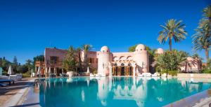 un complejo con piscina frente a un edificio en Palais Mehdi en Marrakech